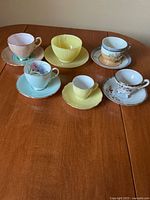 All six teacup and saucer sets arranged on table