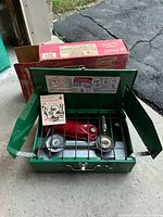 Open camp stove with fuel tank inside and box behind