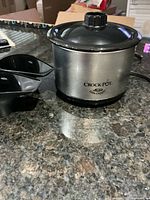 Crock-Pot Little Dipper cooker, lid on, measuring cup beside