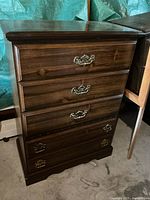 Front view of tallboy showing four drawers and brass-tone handles