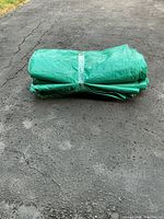 Folded green tarp bundled with plastic wrap