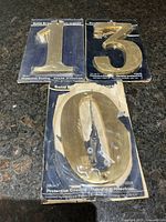 All three Pottery Crafts brass numbers 1,3,0 on cards