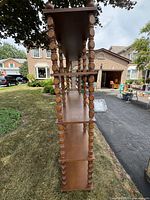 Side view of shelving unit showing spindle supports and tier arrangement