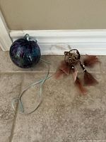 Glass ornament and dreamcatcher on tile floor