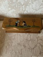 Top view showing painted boy and girl scene on lid