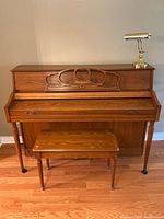 Front view of closed piano with bench