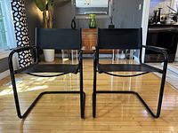 Front view of both black leather cantilever chairs