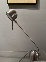 Full side view of lamp showing shade, arm, base and cord