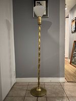 Full view of brass torchiere floor lamp showing shade, stem, and base