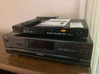 Fluid DVD player on top of Technics CD changer with remote and manual visible