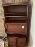 Front view of full bookcase showing shelves, drop-front desk, and cabinet doors