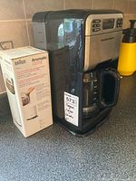 Hamilton Beach coffee maker beside boxed Braun Aromatic grinder