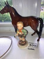 Overall view of Goebel horse and Hummel boy figurine together