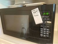 Front view of microwave showing door, display, keypad and brand logo