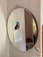 Full view of oval mirror reflecting calendar