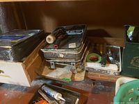 Shelf with stacked paint trays, roller, sealed kit, other supplies