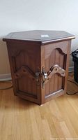 Hexagon wooden side table with paneled doors, front view
