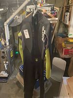 Full view of black and yellow Body Glove wetsuit hanging