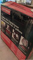 Front of box displaying Craftsman logo and 3-gallon air compressor specifications