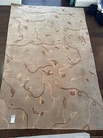 Full view of beige vine-pattern area rug