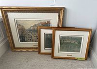 Group shot of three framed prints leaning against wall