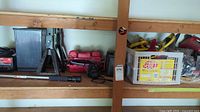 Shelf with battery charger, jack stand, floor jack case, telescoping handle, cables and cords