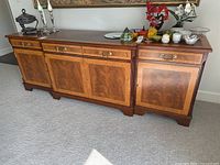 Full front view of mahogany breakfront sideboard showing drawers, doors, top and overall size