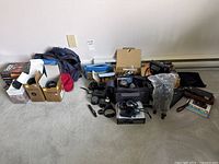 Overview of entire lot with lenses, camera, bags, books, accessories on floor