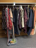 Full rack of women’s clothing and plastic bin with shoes