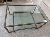 Full view of rectangular metal framed glass coffee table