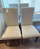 Front view of four matching beige upholstered chairs