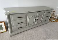 Front view showing six drawers, central doors, gray finish, hardware