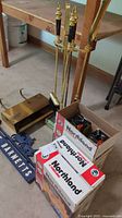Group view: fireplace tools on stand, firewood cradle, mailbox, sign, two Northland boxes