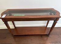 Front view of wood hall table with glass top and lower shelf