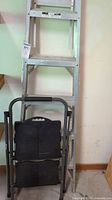 Full view of aluminum ladder with folding step stool in front