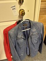 Front view of blue leather jacket with partial view of red jacket