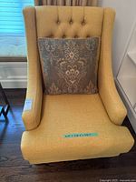 Front view of yellow lounge chair with accent pillow