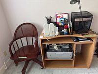 Desk, chair, printer, shredder, speakers, keyboard, lamp, supplies visible
