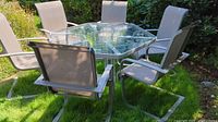 Patio table with six chairs positioned on lawn