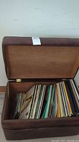 Open brown faux-leather record case showing quantity of vinyl LPs