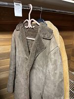 Two sheepskin jackets on hangers