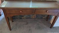 Front view of wooden sofa table with two drawers and tapered legs