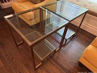 Two square glass and metal side tables side-by-side