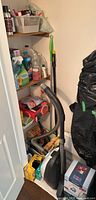 Closet shelves with vacuum, cleaning bottles, boxes of supplies