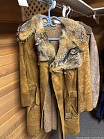 Full view of suede shearling coat hanging