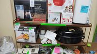Shelf view showing Perfect Blend Pro blender box, Braun manual visible, and enamel roaster