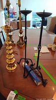 Brass candlestick, pair of wrought iron stands, snuffer on candle box