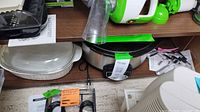 Shelf with casserole dish, slow cooker, organizer, corkscrew visible