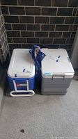 Two coolers side by side on patio floor