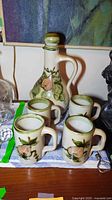 Full set showing decanter with stopper and four mugs
